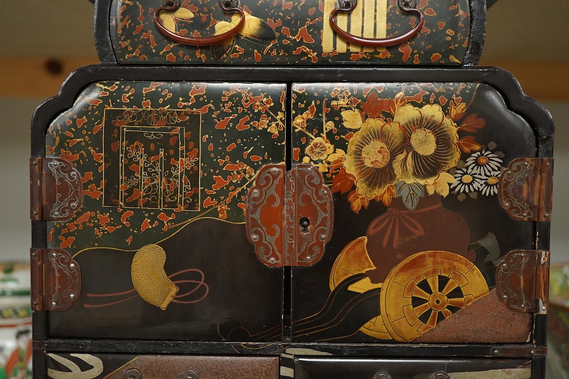 A Japanese gilt decorated black lacquer table cabinet, fitted with seven drawers, with key, 35cm high